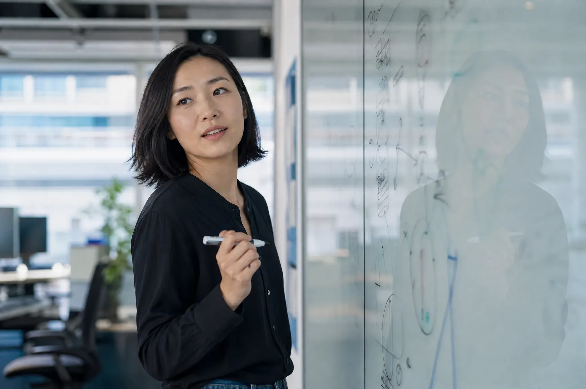 A platform product lead mapping a workflow on a glass whiteboard